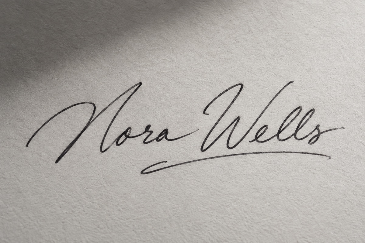 Firma ficticia de Nora Wells sobre papel gris con una sombra suave
